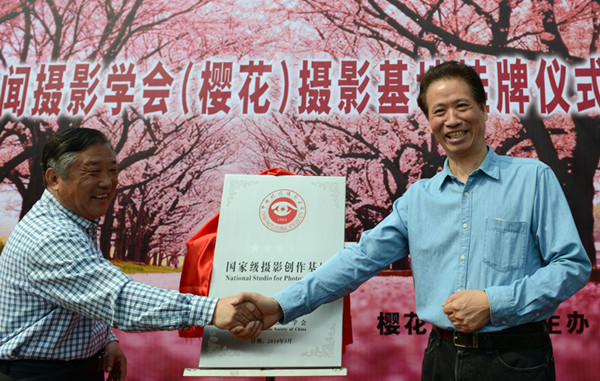 国家级摄影创作基地挂牌邹平?；ㄉ?/></a></p>
<p>　　中国新闻摄影学会会长徐祖根（右）和樱花山景区创业人颜景江共同为摄影创作基地揭牌。</p>
<p>　　3月26日，邹平樱花山景区?；ㄅ牛缭扑蒲?。由中国新闻摄影学会设立的国家级摄影创作基地在此举行挂牌仪式。中国新闻摄影学会会长徐祖根和樱花山景区创业人颜景江共同为摄影创作基地揭牌。</p>
<p>　　由邹平嘉业生态园有限公司民营企业家颜景江投资近2亿元兴建的邹平?；ㄉ骄扒?，总面积3600亩。经过10年的艰苦奋斗，原来的荒山、垃圾场，变成了山青水秀、花团锦簇的特大花园。?；?、玉兰、枫香、水杉等八十余种珍稀植物遍植山间、路旁，吸引了各地游客前来休闲观赏。</p>
<p>　　王呈选摄影报道</p>
<!--/enpcontent--><div width=