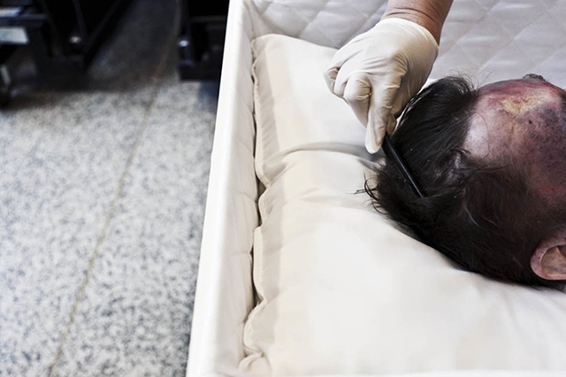 工作人员在给一位死者梳好头发.jpg