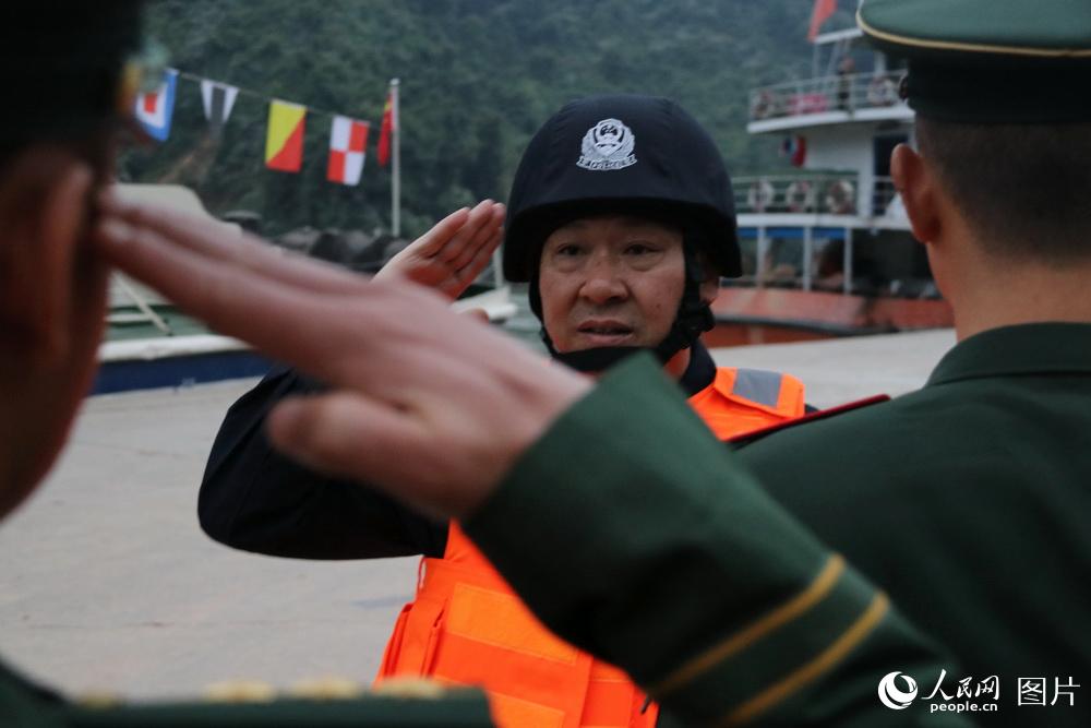 图2 云南公安边防总队副总队长李勇为参加联巡执法的边防警察送行，一一握手敬礼。