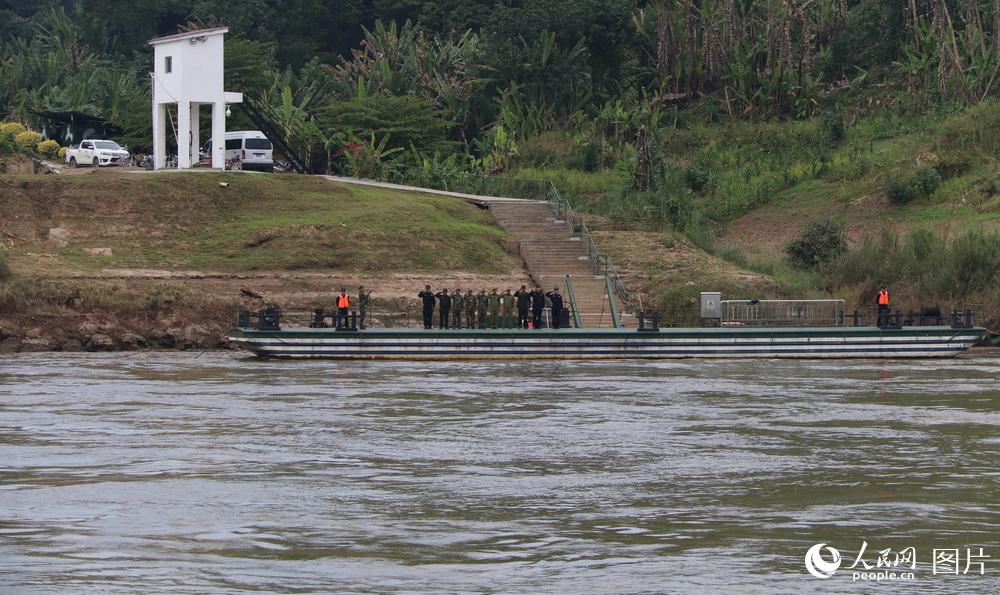 图15 联巡编队途径沿河各国港口码头时，各国值守军警都列队向编队致敬，这是老挝人民军和中国边防警察在老挝班相果联络点码头向编队敬礼。