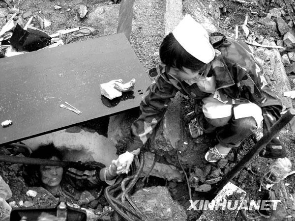 2008年5月13日，北川，一位护士不停地与一位被困孩子说话，鼓励他坚强活下去，等待救援。