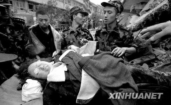 2008年5月13日上午，北川，救援人员从废墟中救出一名幸存者。