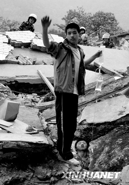 2008年5月13日6时许，北川中学高一学生李阳为被埋废墟的同学廖波拎着输液吊瓶。这幅照片传播甚广，照片中的李阳后来被人称为“吊瓶男孩”，而廖波则被称为“夹缝男孩”。